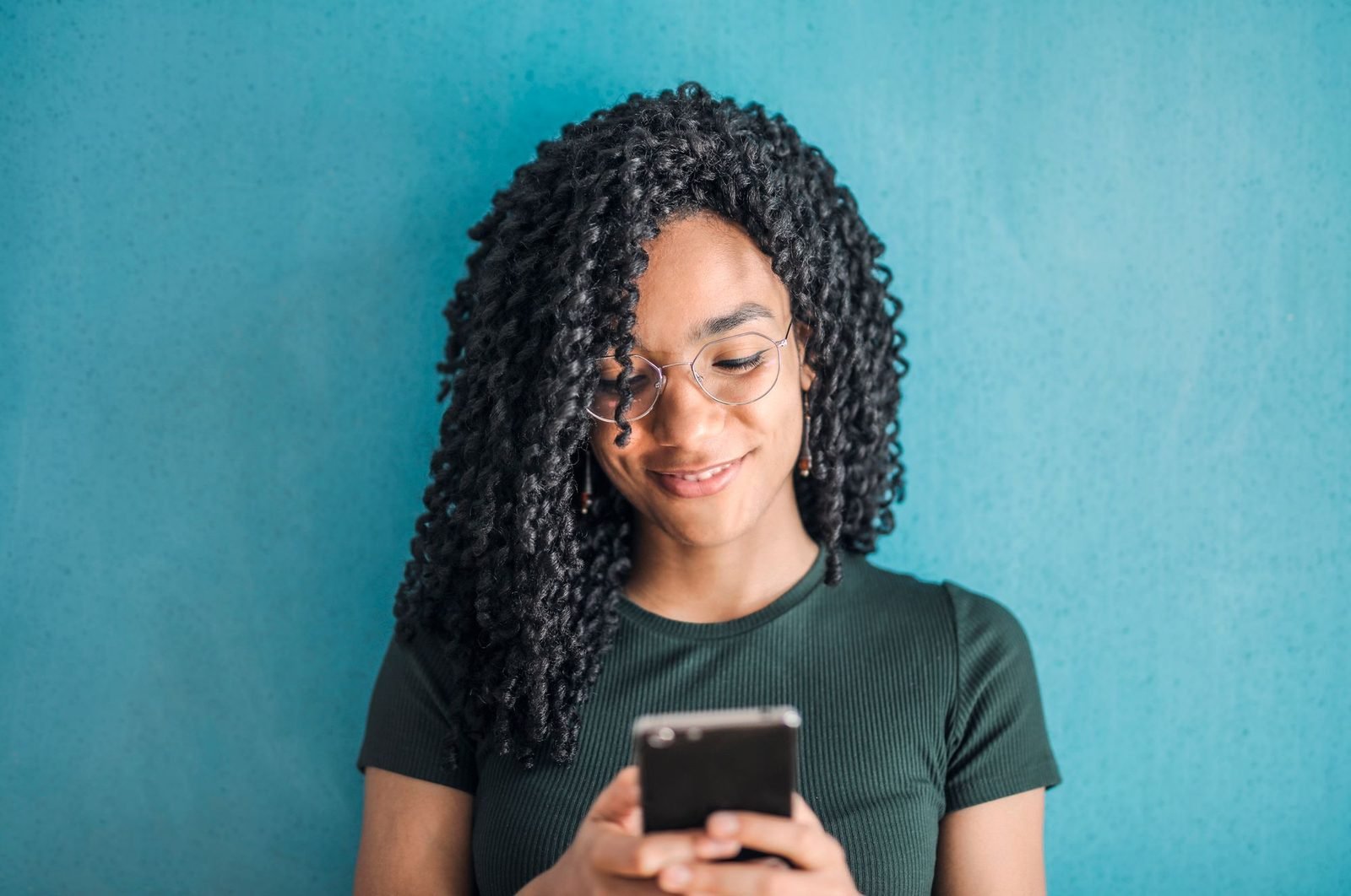 A smiling young woman using an app on her phone